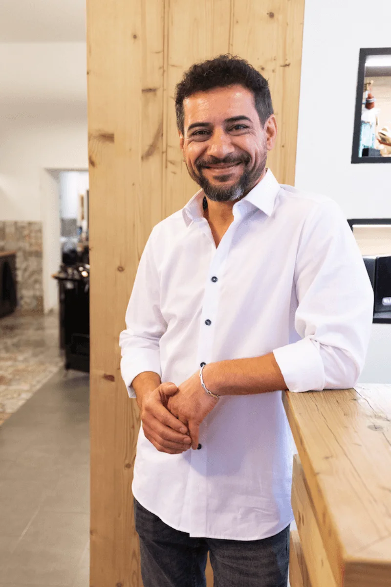 Inhaber Beyti lächelt in Kamera – Neusser Friseursalon Team