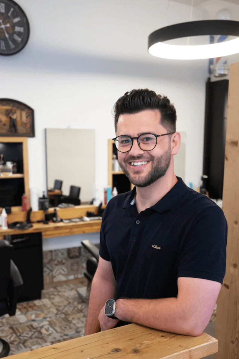 Mitarbeiter lächelt in Kamera – Neusser Friseursalon Team
